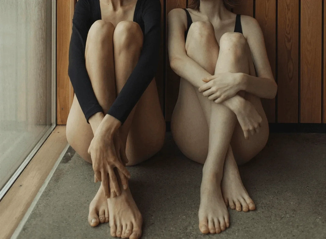 Two women relaxing in a wood-panelled sauna.