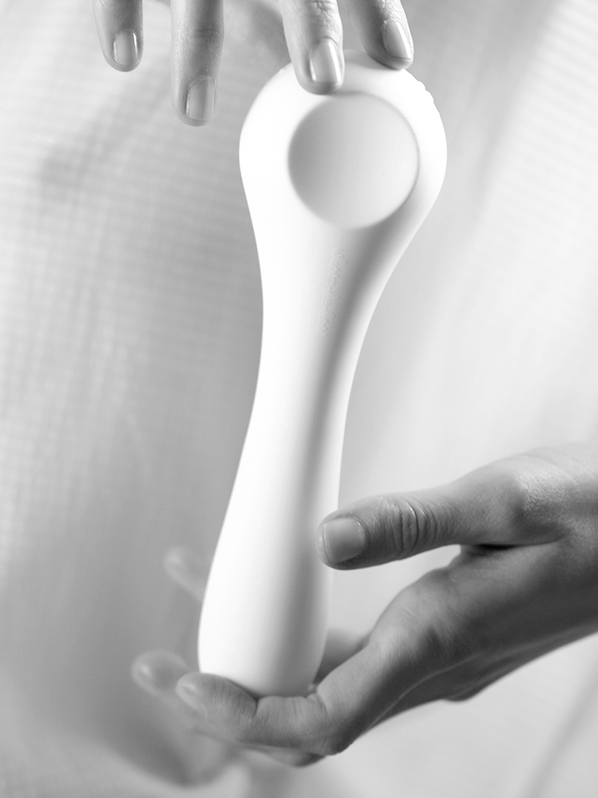 Close-up of a white flexible Whoop-de-doo Classic vibrator made of medical-grade silicone held by hands.