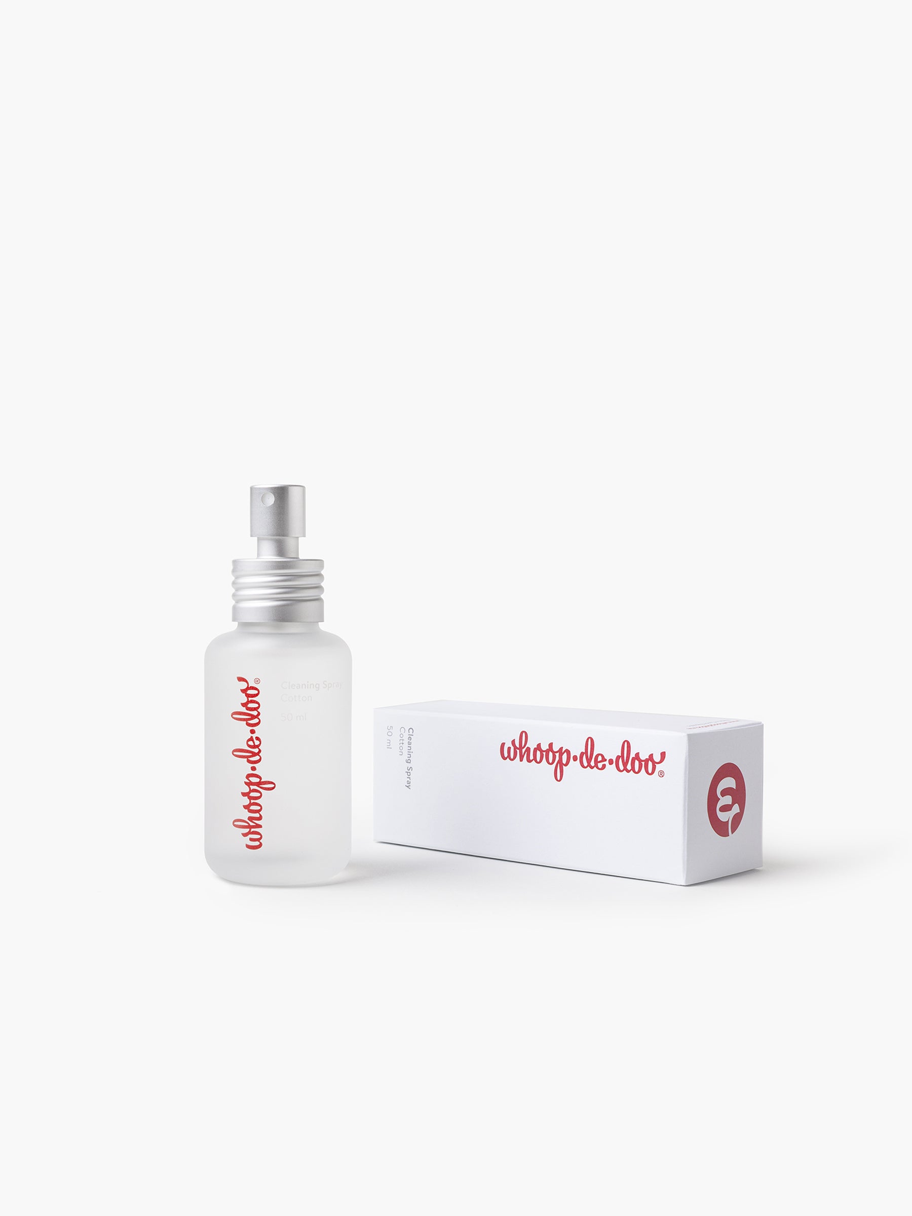 Whoop-de-doo intimate toy cleaning spray Cotton in a frosted glass bottle displayed next to its minimalist white packaging.