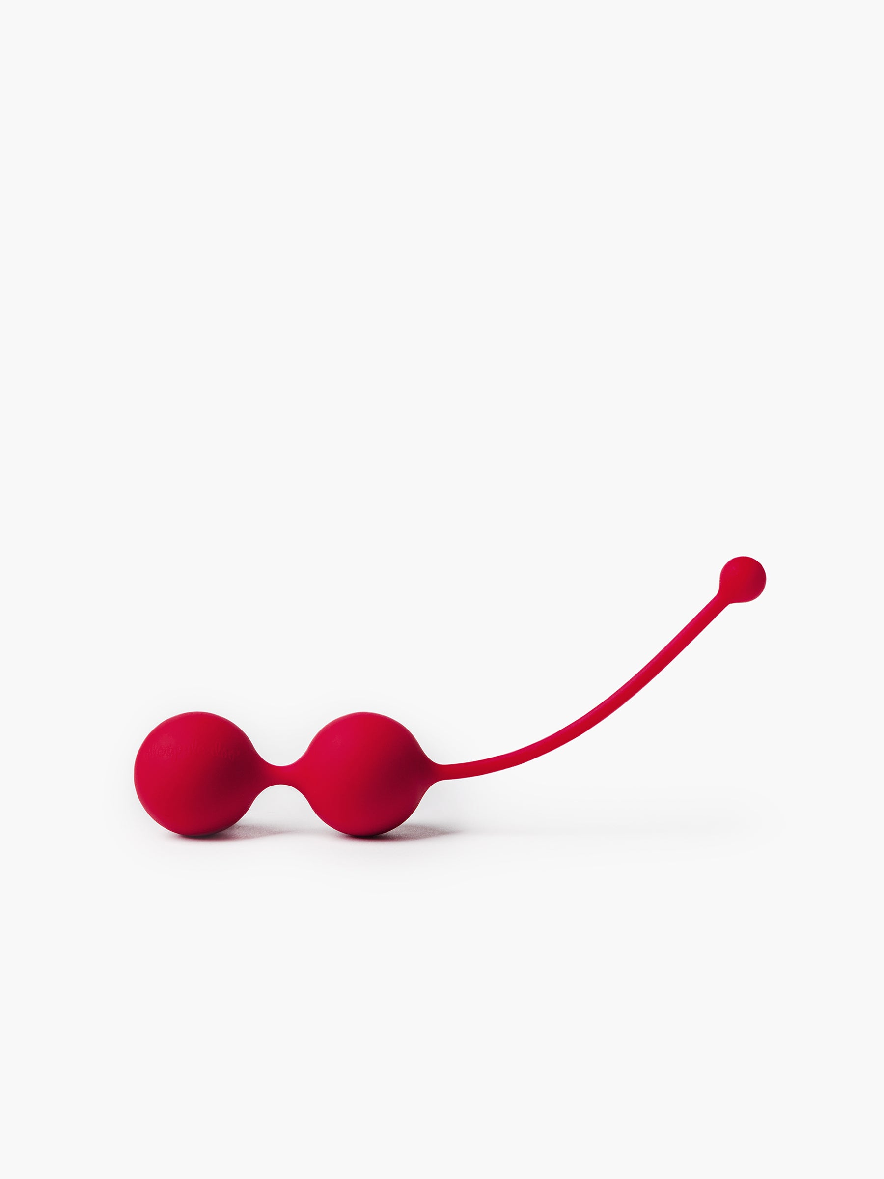 Close-up of red Whoop-de-doo Venus balls featuring an anatomically curved silicone stem for easy and safe removal during pelvic workouts.