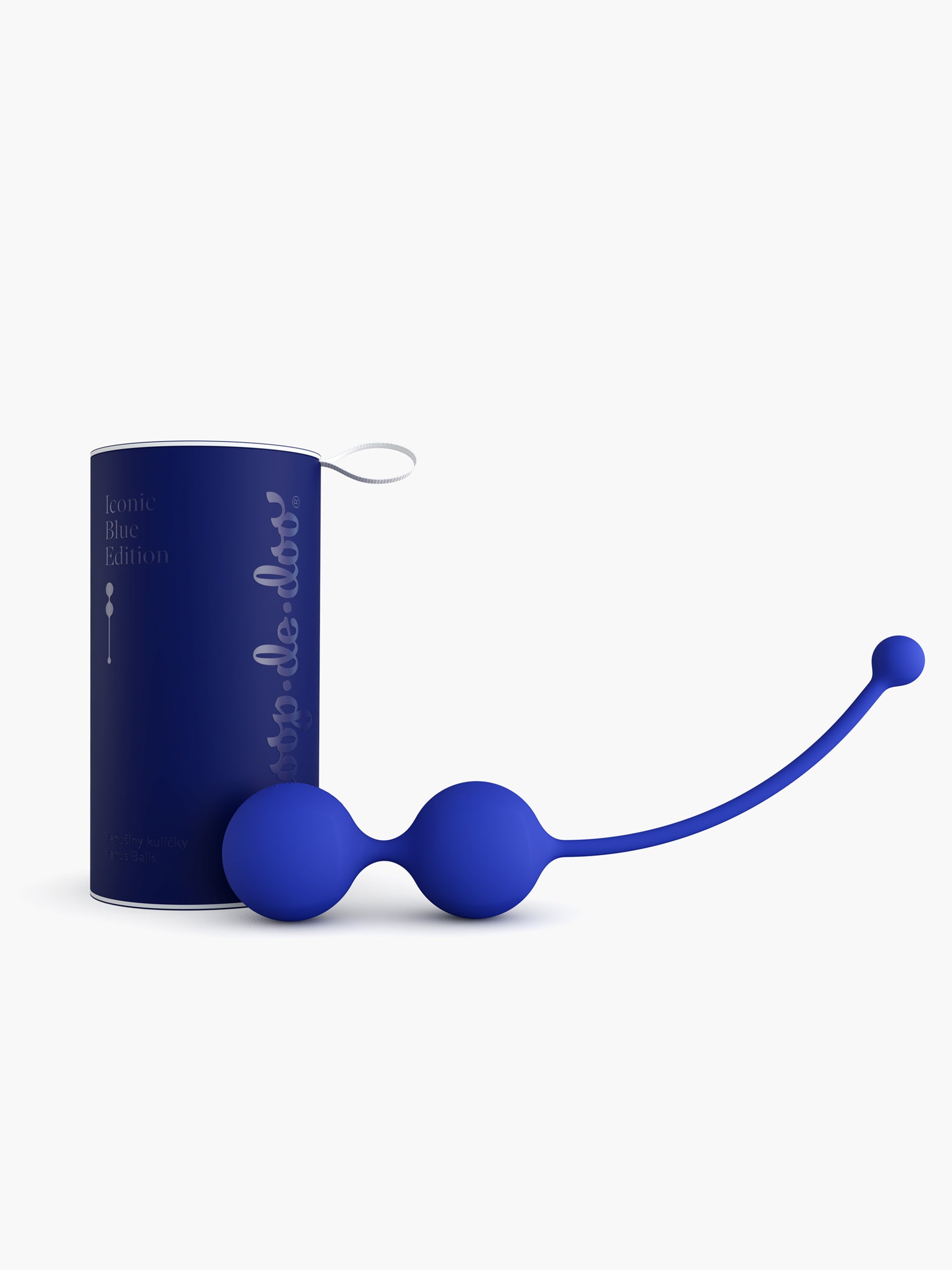 Dark blue Whoop-de-doo Kegel balls from the limited Iconic Blue Edition displayed next to their elegant cylindrical gift packaging.