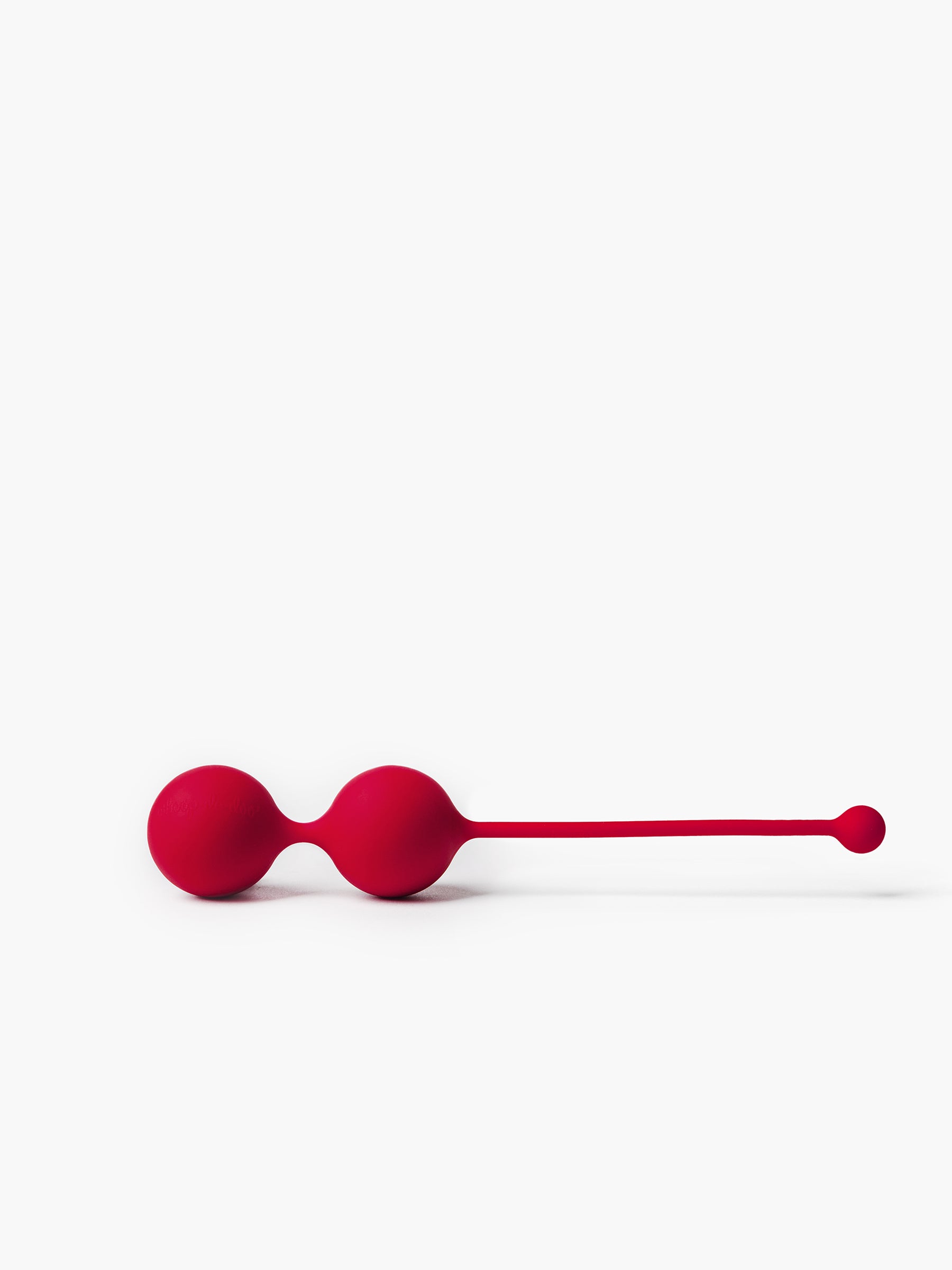 Product close-up of red Whoop-de-doo Kegel balls made of medical-grade silicone for pelvic floor muscle training.