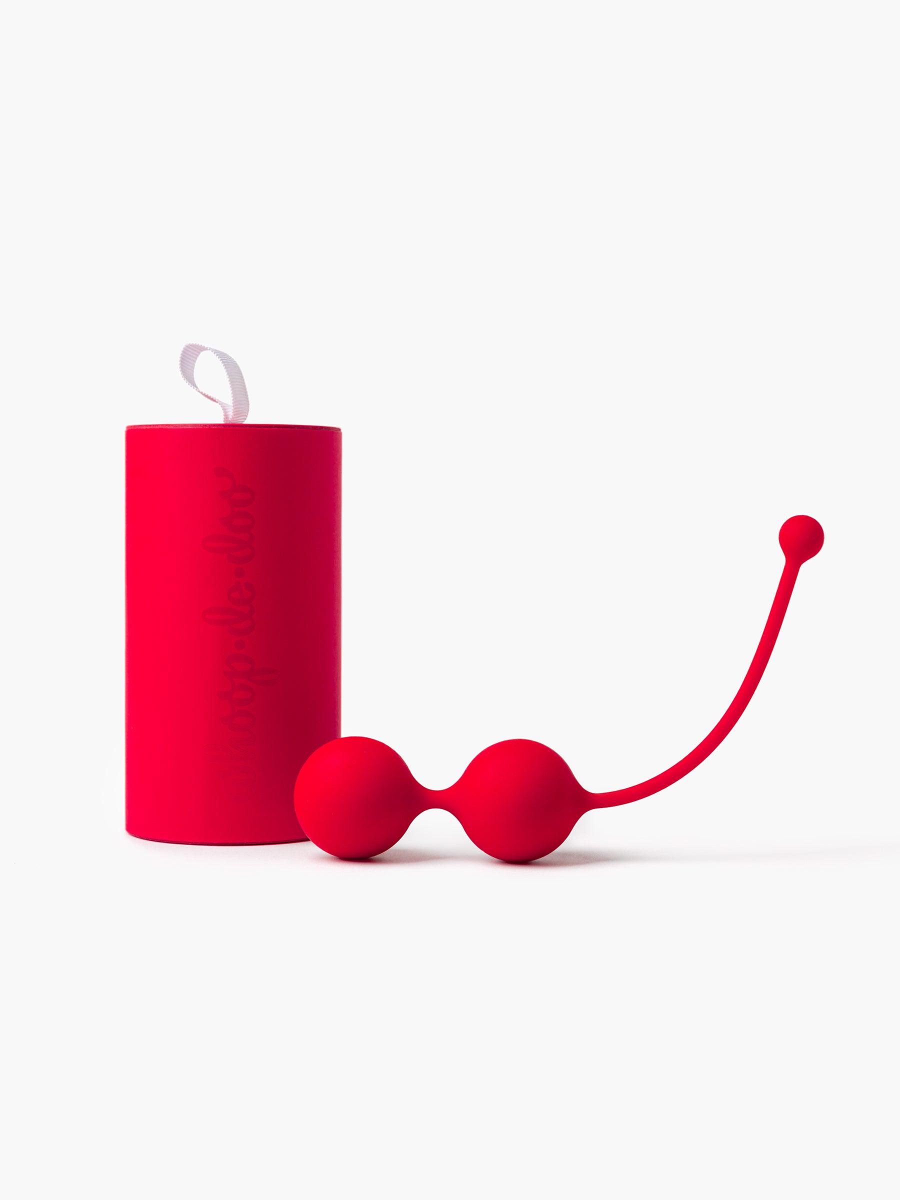 Red Whoop-de-doo Kegel balls made of medical-grade silicone displayed in front of their matching red luxury gift tube.