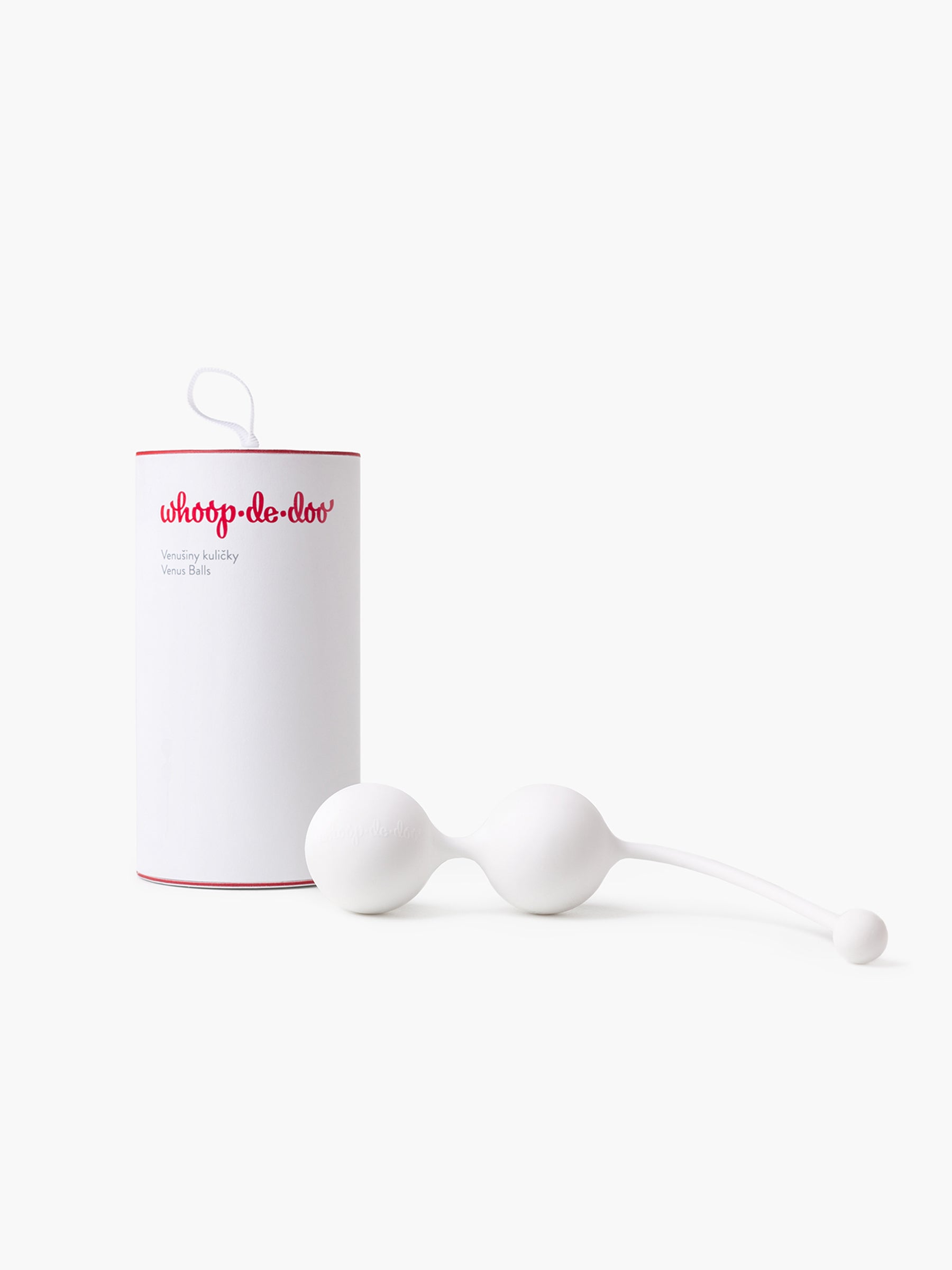 White Whoop-de-doo Kegel balls made of medical-grade silicone placed in front of their elegant white gift tube with a red logo.