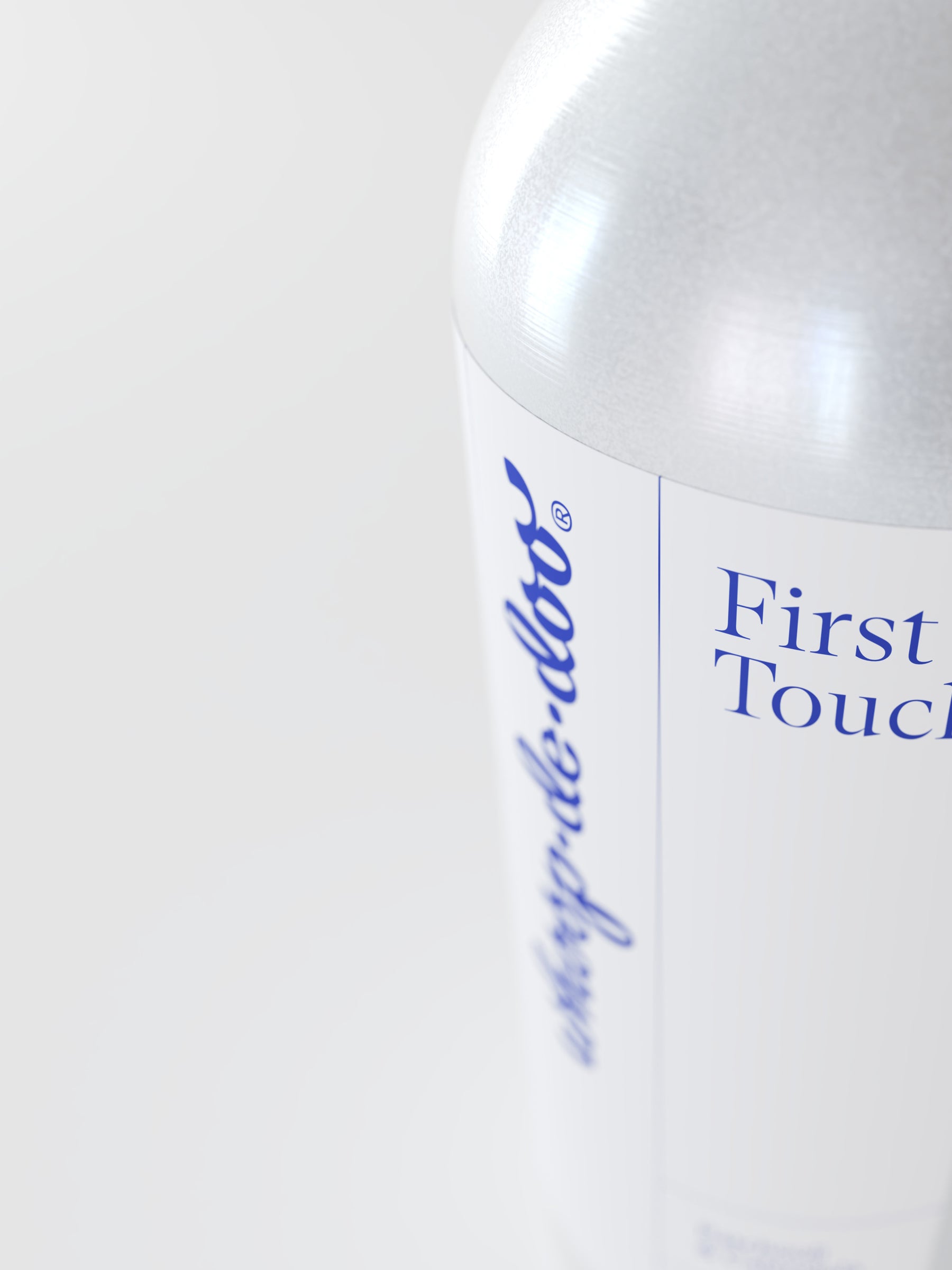 Macro close-up of the Whoop-de-doo First Touch lubricant aluminum bottle showcasing the blue logo on a minimalist white label.